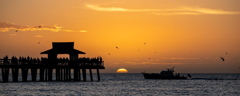 Charter yacht sailing by Naples Pier